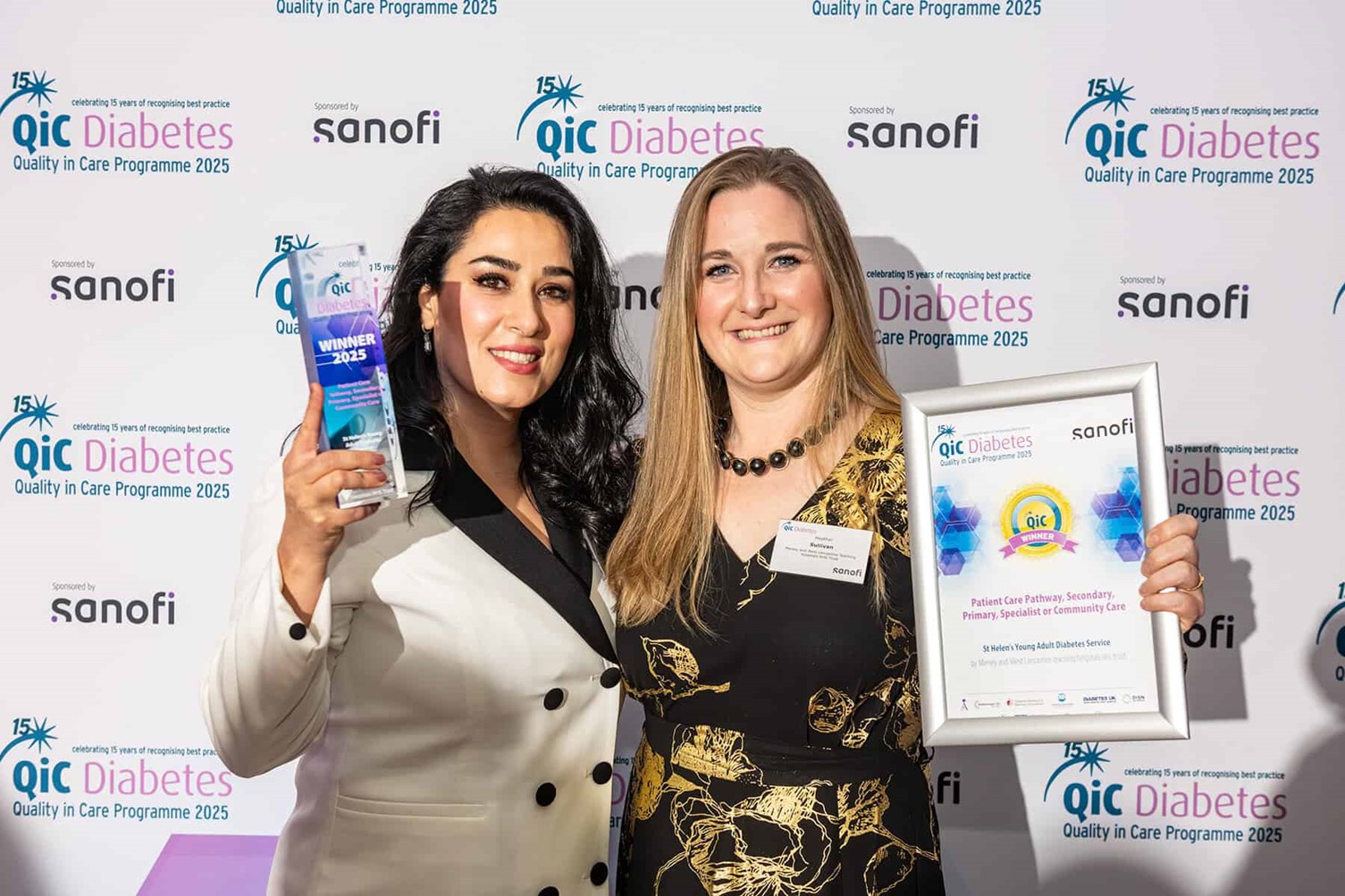 Two women holding a certificate and a water bottle